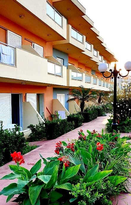 vibrant hotel exterior with flower garden and balconies