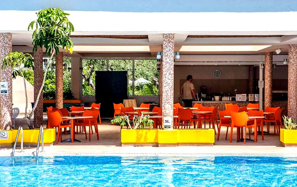 vibrant poolside bar with bright orange seating