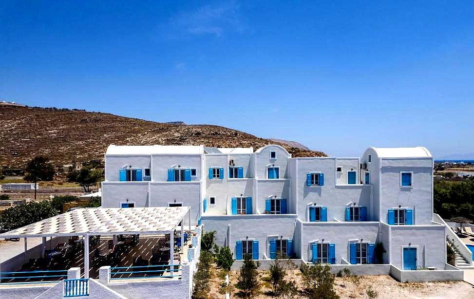 white building with blue details and hill background