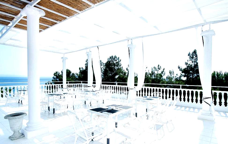 white outdoor dining terrace with sea view